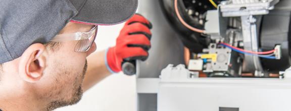 Male technician visually inspecting heating equipment