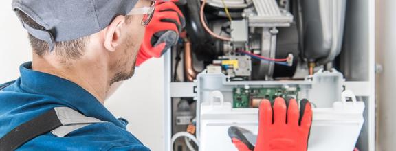 Technician with red gloves examines complex machinery