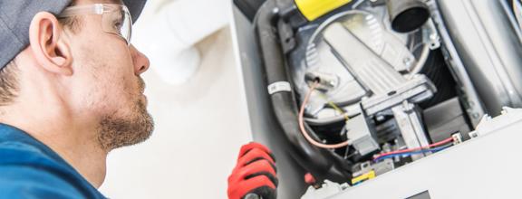 Male technician visually inspecting heating equipment
